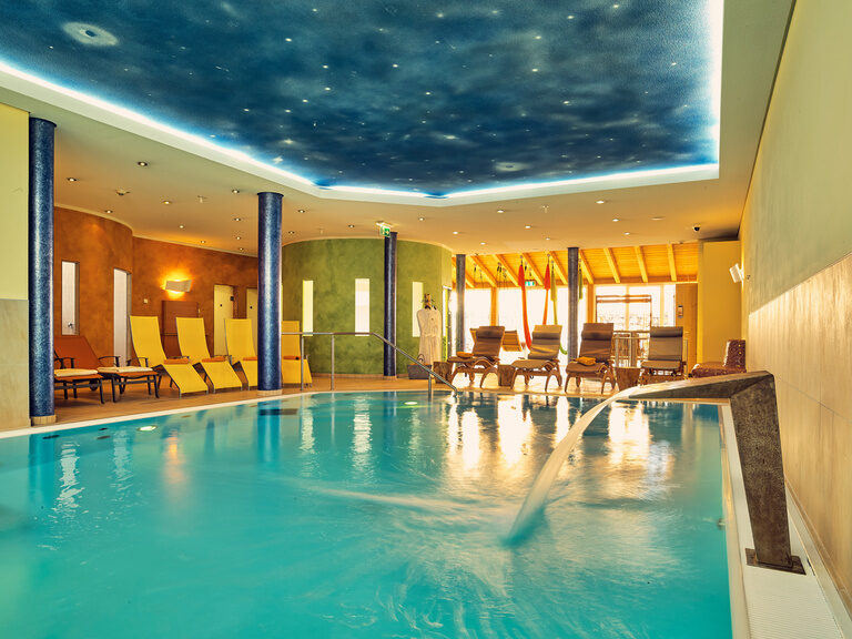 Blick vom Pool auf die Wellnessliegen